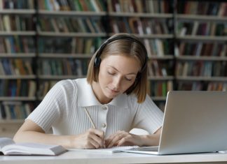 How Do You Edit a Graduate School Essay? Serious student girl listening to audio tutorials from wireless headphones,