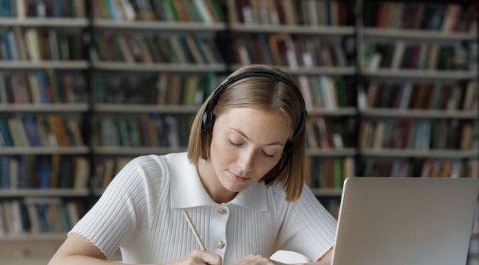 How Do You Edit a Graduate School Essay? Serious student girl listening to audio tutorials from wireless headphones,