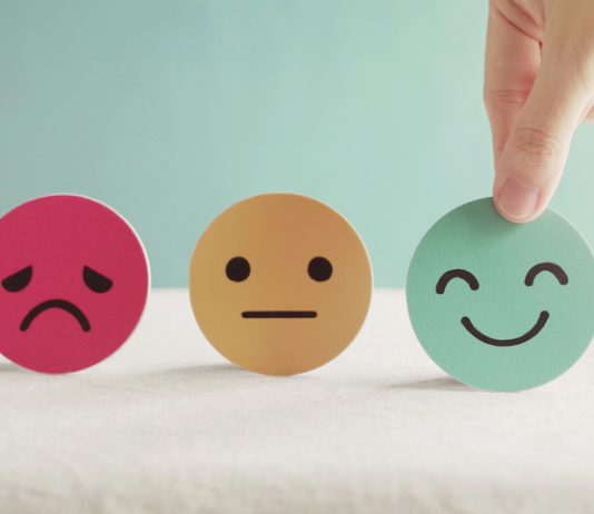 Hand choosing green happy smiley face paper cut, product, user, service feedback rating and customer reveiw, experience, satisfaction survey, psychology mental health test concept