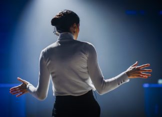 Successful Female Motivational Speaker on Stage, Talking about Happiness, Diversity, Empowerment, Success, Leadership, STEM and How to Be Productive. Woman Presenter Leads Tech Business Conference