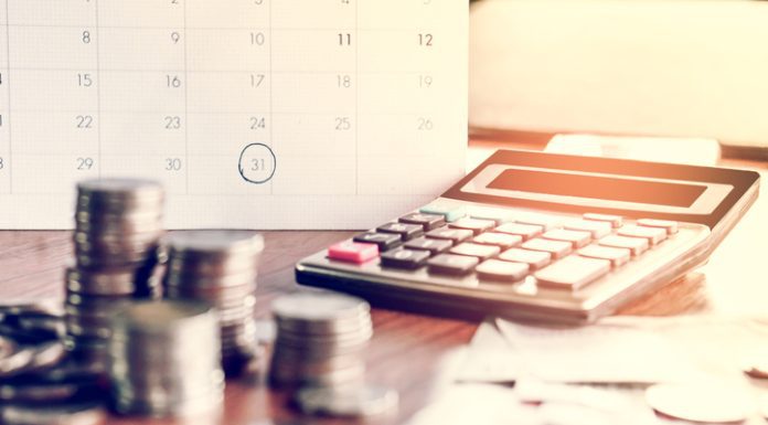 What are the Very Basic Things Which People Need to Know About the EMI Calculator for a Business Loan? debt collection and tax season concept with deadline calendar remind note,coins,banks,calculator on table