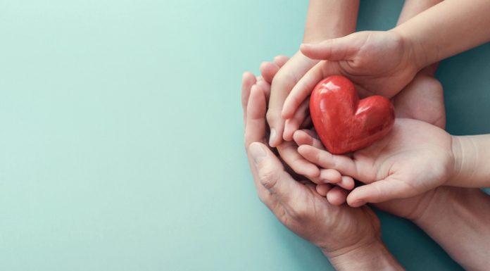 adult and child hands holding red heart on aqua background, heart health, donation, CSR concept, world heart day, world health day, family day