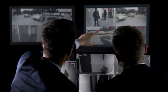 Private agents monitoring CCTV footage, searching for criminal, discussion