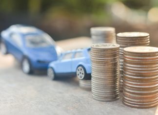 Coins stack and car model on wood table