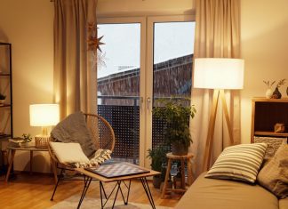 View of a warm light cozy living room in winter with a snowstorm outside