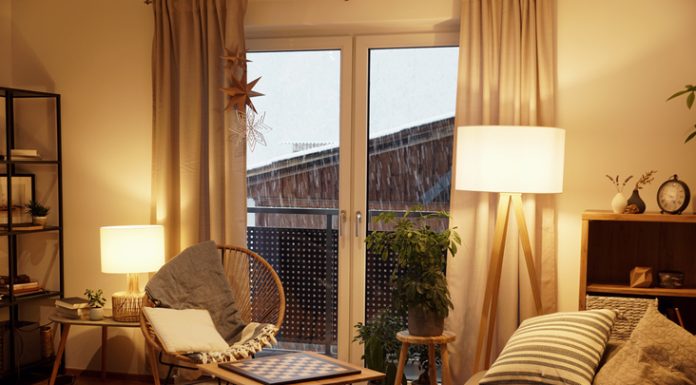 8 Great Ideas on How to Make Your Home Lighting Better View of a warm light cozy living room in winter with a snowstorm outside