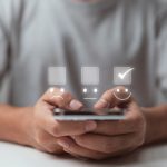 A businessman uses mobile app to make a smiling face on the touch screen.