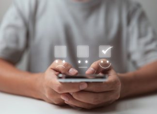 A businessman uses mobile app to make a smiling face on the touch screen.