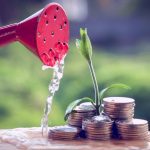 How to Save Money as a Startup Money and plant with hand