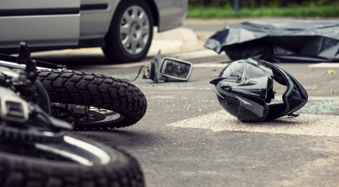 Why You Need a Motorcycle Accident Lawyer Motorcycle and helmet on the street after dangerous traffic inci