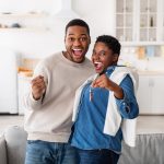 Happy African American couple showing keys of their new apartment