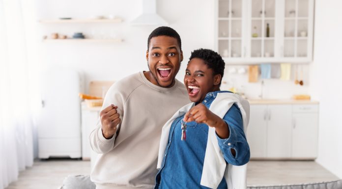 Happy African American couple showing keys of their new apartment