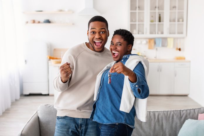 Happy African American couple showing keys of their new apartment