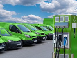 Electric vehicles charging station on a background of a row of vans