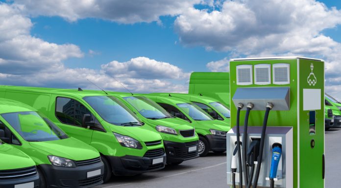 Electric vehicles charging station on a background of a row of vans