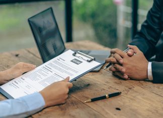 Hiring concept HR manager is interviewing a job candidate filling out a resume on a job application form to be considered for a job