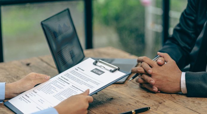 Hiring concept HR manager is interviewing a job candidate filling out a resume on a job application form to be considered for a job
