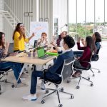 Group of young attractive asian creative design team meeting at office celebrating success or winner. Asian employee engaged together with effective and productive meeting and happy workplace concept.