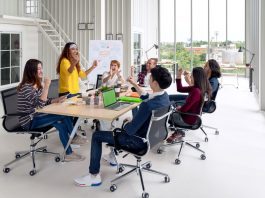 Group of young attractive asian creative design team meeting at office celebrating success or winner. Asian employee engaged together with effective and productive meeting and happy workplace concept.