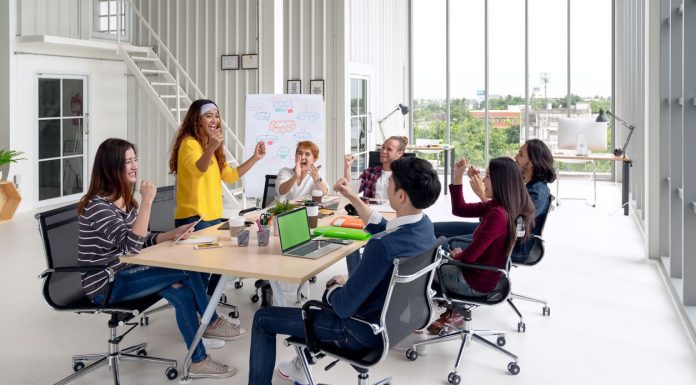 Group of young attractive asian creative design team meeting at office celebrating success or winner. Asian employee engaged together with effective and productive meeting and happy workplace concept.