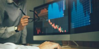 How do I Choose a Stockbroker in India? Two business stock brokers stress and looking at monitors displaying financial information