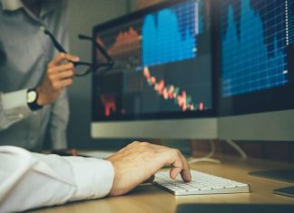 How do I Choose a Stockbroker in India? Two business stock brokers stress and looking at monitors displaying financial information