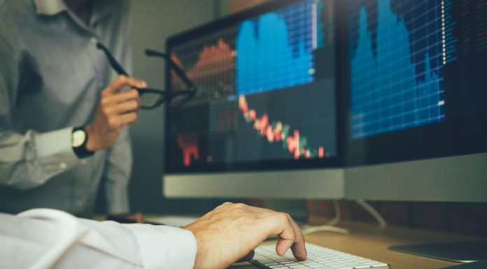 Two business stock brokers stress and looking at monitors displaying financial information