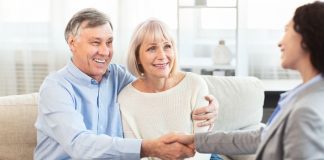 The Importance of Health Insurance for Senior Citizens: A Comprehensive Guide Female Real Estate Agent handshaking happy mature couple at home