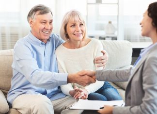 The Importance of Health Insurance for Senior Citizens: A Comprehensive Guide Female Real Estate Agent handshaking happy mature couple at home