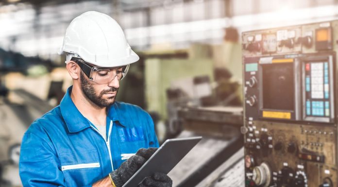 Engineer setup the CNC machine with G-Code programming upload from Computer Tablet for technology in heavy industry