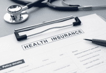 Health Insurance form and stethoscope on desk