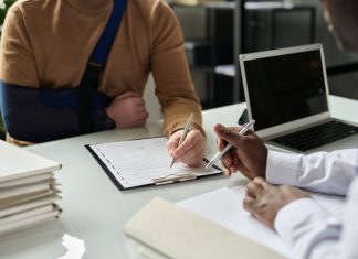 Close up of man filling in medical insurance form