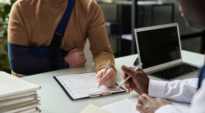 Close up of man filling in medical insurance form