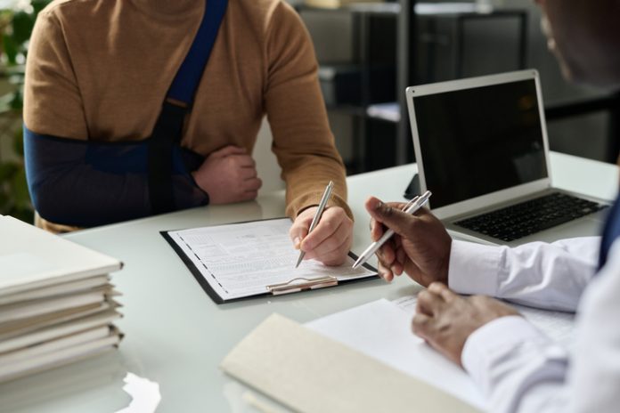 Close up of man filling in medical insurance form Close up of man filling in medical insurance form