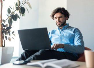 Businessman using laptop sitting on bean bag in office