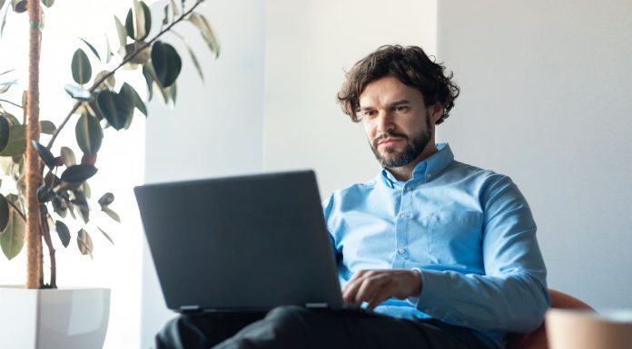 Businessman using laptop sitting on bean bag in office