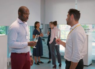 14 Ideas to Take Your Corporate Events to the Next Level Side view of cheerful multicultural businessmen holding champagne glasses and talking in the event