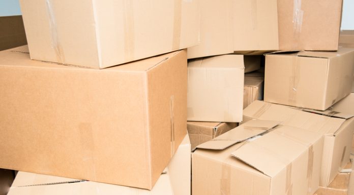 Detail of many cardboard boxes full of household items during a move.