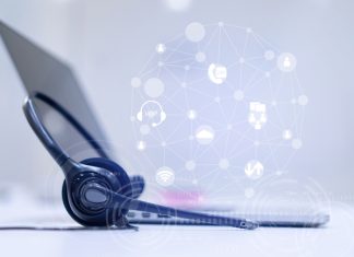 close up headset of call center and VOIP communication with futuristic virtual icon telecommunication technology on office table in monitoring room for network operation job concept