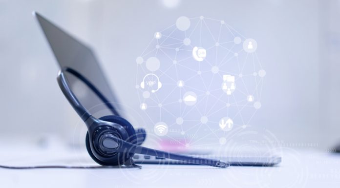 close up headset of call center and VOIP communication with futuristic virtual icon telecommunication technology on office table in monitoring room for network operation job concept