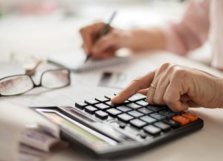 DiamondCapitals Offering Exclusive Benefit Program For Senior Clients Pension calculation concept, old hands counting finances on a home calculator , close- up