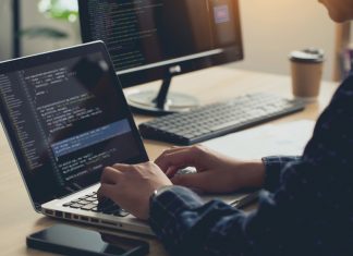 Professional Development programmer typing on a laptop Computer Keyboard. Screens Show Coding Language User Interface. Program Development, software, and coding technology, artificial chat, Website design.
