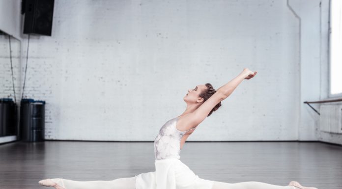 Slim graceful young woman doing the splits