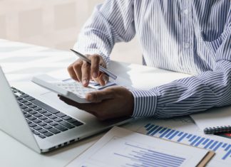 Businessman using a calculator to calculate the company's financial results in the office and tax, accounting, statistics and financial analysis.