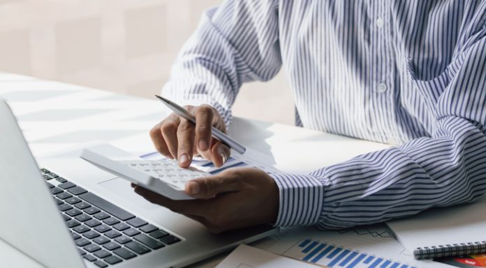 Businessman using a calculator to calculate the company's financial results in the office and tax, accounting, statistics and financial analysis.