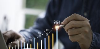 Businessman use electronic pen writing rising colorful graph from 2023 to 2024 year of business planing and stock investment growth concept.