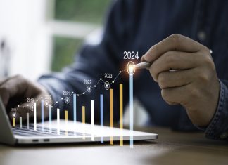 Businessman use electronic pen writing rising colorful graph from 2023 to 2024 year of business planing and stock investment growth concept.