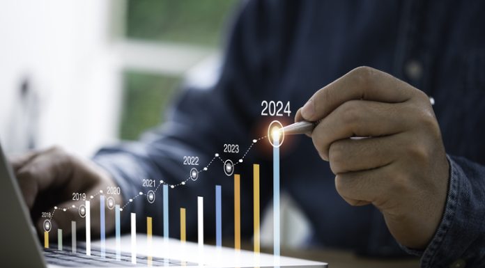 Businessman use electronic pen writing rising colorful graph from 2023 to 2024 year of business planing and stock investment growth concept.