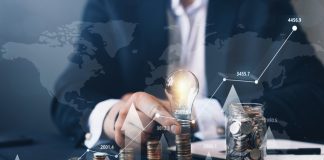 Navigating Through Trader Funding Options: FundedNext And Other Top Competitors Businessman holding illuminated light bulb