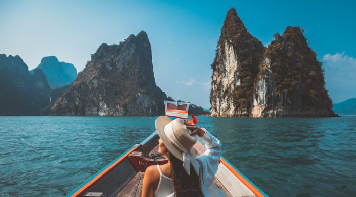 Traveler asian woman relax and travel on Thai longtail boat in Ratchaprapha Dam at Khao Sok National Park Surat Thani Thailand